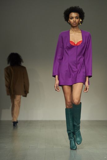 La mini-robe avec soutien-gorge coloré apparent de Marta Jakubowski, à porter avec des bottes hautes, pour un look rétro sexy. Londres, le 16 février 2018.