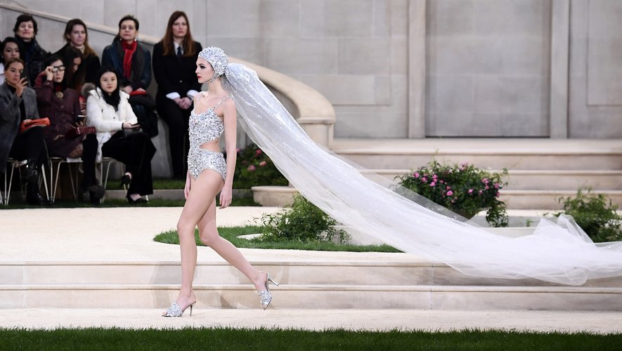 La tenue de mariée de Chanel, composée d'un maillot de bain et d'un bonnet de bain brodés et d'un voile blanc pailleté argent. Collection haute couture SS19. Paris, le 22 janvier 2019.