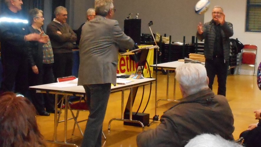 Passage de témoin avec un ballon de rugby entre Yves Valls et Roland Joffre, le maire de Livinhac qui accueillera le 33e Téléthon.