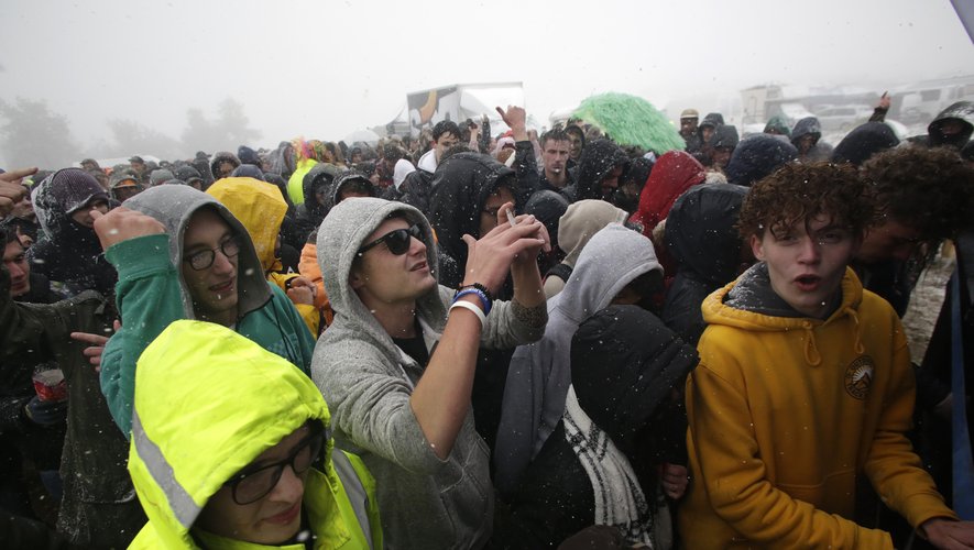 Participants of the Teknival techno music festival dance as snow falls on May 4, 2019 in Feniers, central France