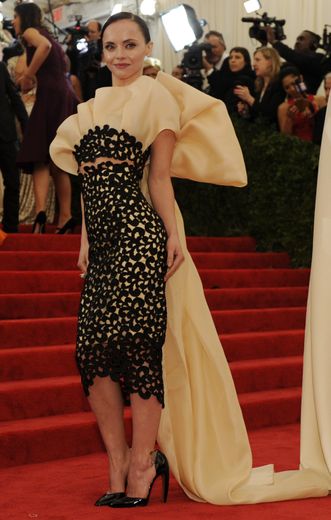 Christina Ricci fait une arrivée remarquée au MET Gala en 2012, arborant une robe au bustier plissé signé Thakoon. Côté face, la robe se prolonge par une cape en forme de noeud géant. New York, le 7 mai 2012.