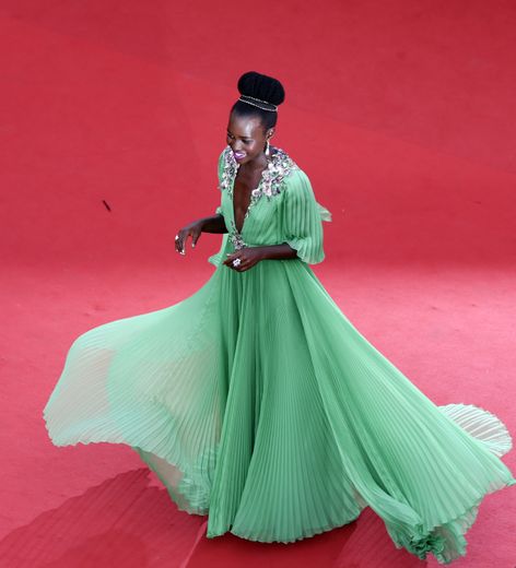Lupita Nyong'o arborait un look beauté sensationnel sur le tapis rouge cannois en 2015. Elle avait associé un rouge à lèvres rose magenta à un chignon haut régalien magnifié par un bandeau scintillant. Le 13 mai 2015