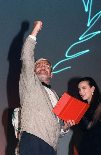 Le réalisateur français Maurice Pialat lève le poing en réponse aux sifflets du public, le 19 mai 1987 au festival de Cannes, alors qu'il vient de remporter la Palme d'Or pour son film "Sous le soleil de Satan".