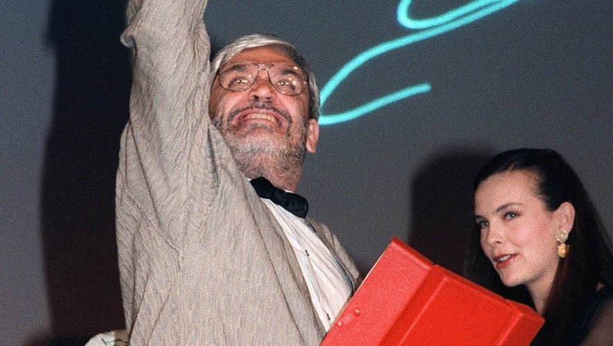Le réalisateur français Maurice Pialat lève le poing en réponse aux sifflets du public, le 19 mai 1987 au festival de Cannes, alors qu'il vient de remporter la Palme d'Or pour son film "Sous le soleil de Satan".