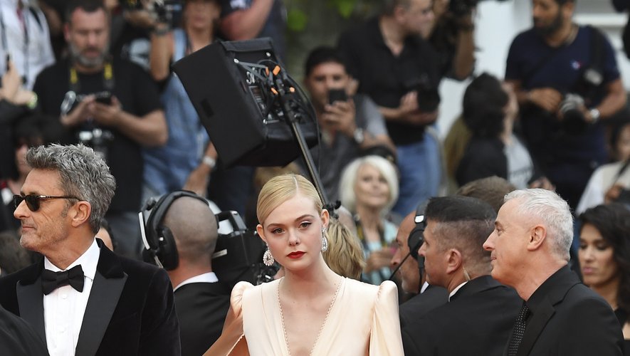 Elle Fanning dans une robe en soie rose tendre et sa cape, par Gucci. Cannes, le 14 mai 2019.
