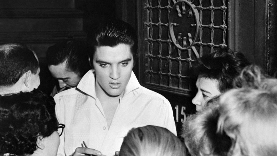 Elvis Presley entouré par des fans après un concert en 1958
