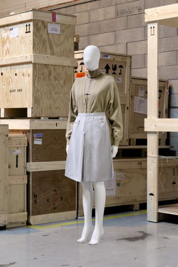 Martin Margiela, printemps-été 1997 : veste Stockman en toile de lin brut imprimée à l'encre, demi-jupe courte en toile gris clair retenue par un élastique, cardigan long en maille beige à épaulettes.