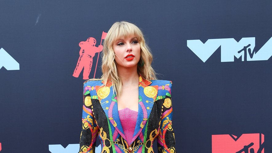 Taylor Swift a misé sur la couleur, arborant une veste blazer aux épaules marquées associée à un crop top rose. Le tout est entièrement incrusté de cristaux Swarovski, et signé Atelier Versace. Newark, le 26 août 2019.