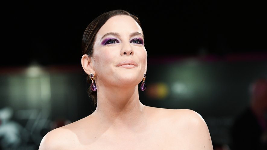 La star hollywoodienne Liv Tyler affichait de saisissantes paupières violettes assorties à ses boucles d'oreilles. Des lèvres nude et un teint velouté adoucissaient ses choix esthétiques.