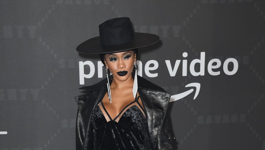 Saweetie dans une petite robe noire ultra sexy surmontée d'un long manteau et accessoirisée d'un chapeau à bord large. New York, le 10 septembre 2019.