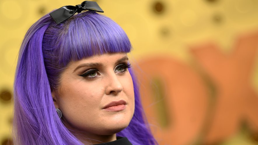 Kelly Osbourne, a ajouté un noeud pour accessoiriser sa coiffure violette. Elle a mis l'accent sur son regard avec de longs cils effet plume pour adoucir son look voyant.