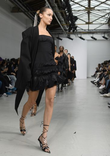 La femme est plus sensuelle que jamais chez Mugler qui propose des robes courtes ornées de volants, surmontées de vestes amples aux épaules larges. Paris, le 25 septembre 2019.