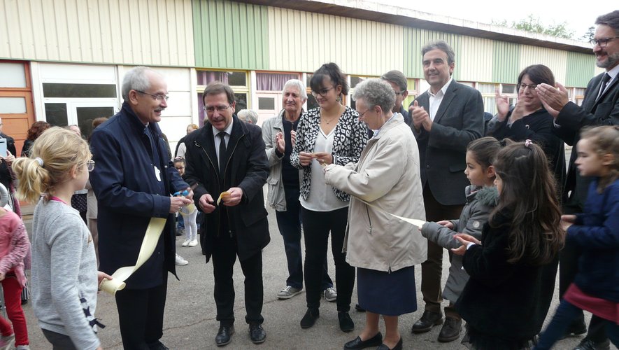 Monseigneur Fonlupt, le maire J.-P.  Keroslian et la directrice P. Latieule partageant les morceaux du ruban inaugural.