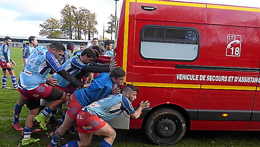 Les rugbymen poussant le véhicule des pompiers, comme en mêlée