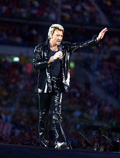 Johnny Hallyday fait un geste en direction du public venu l'écouter, le 05 septembre 1998 au Stade de France de Saint-Denis, lors du premier concert de la star devant 70.000 spectateurs