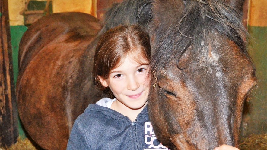Complicité et bonheur partagé entre Marie, jeune cavalière et son cheval, lors des soins aux animaux au poney-club de Ferrals.
