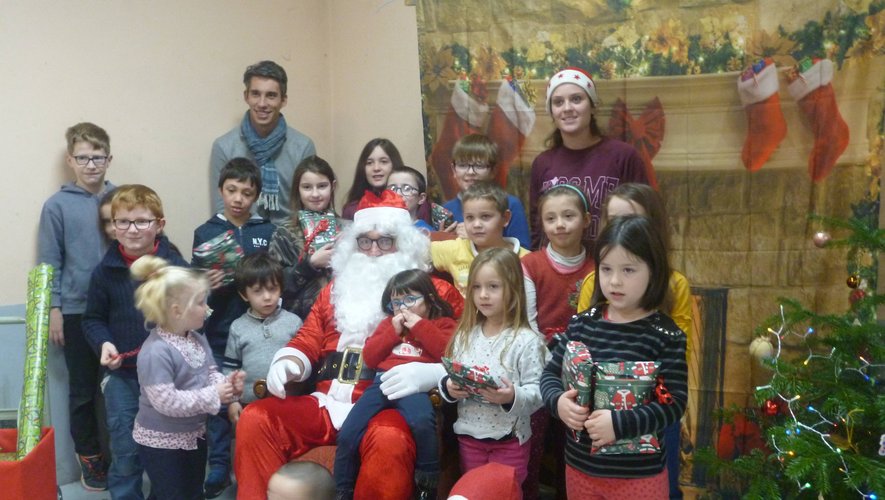 Les enfants heureux de poser pour la photo avec le Père Noël et l'équipe enseignante.