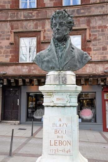 Né en 1778, Blazy Bou dit  Lebon était tailleur à Rodez. En 1846, il légua sa fortune à la Ville de Rodez - son buste trône place du Bourg - dont les intérêts devaient être distribués à des retraités méritants ou à des jeunes filles pauvres. 	
