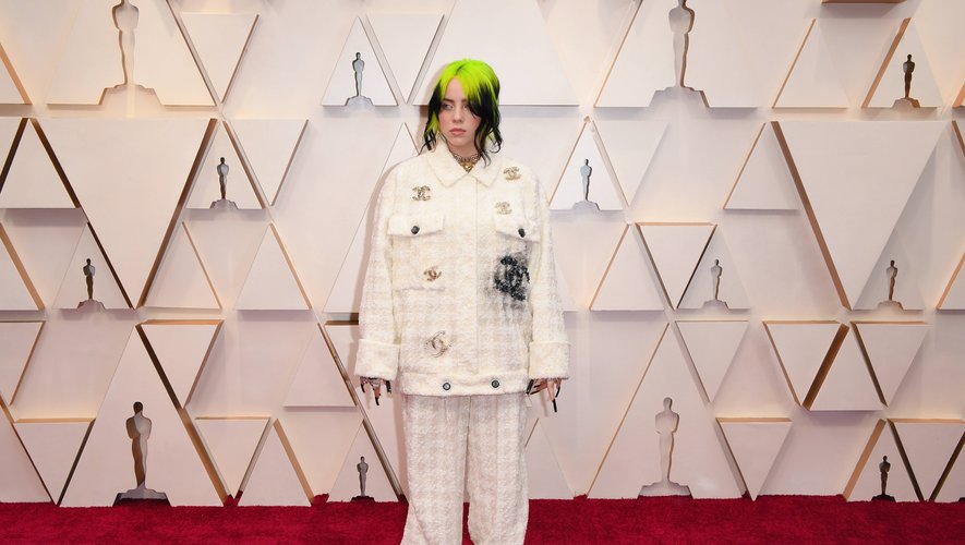 Exit les robes glamour, Billie Eilish privilégie un ensemble oversize Chanel composé d'une veste et d'un pantalon, qu'elle accessoirise même avec un chouchou signé de la maison de la rue Cambon. Hollywood, le 9 février 2020.