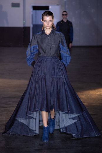 Le denim est bel et bien présent chez Koché qui propose une série de longues jupes imposantes, plus courtes devant que derrière, pour un style féminin et streetwear, élégant et décontracté, tout en contrastes. Paris, le 25 février 2020.