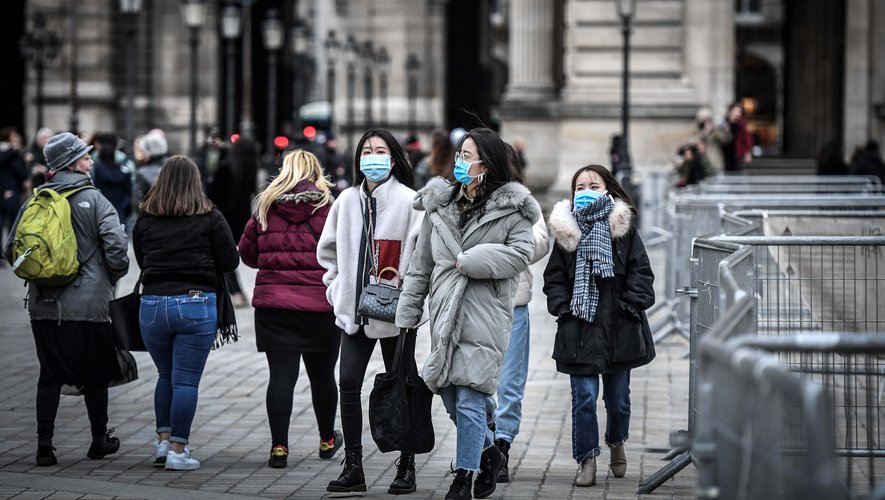Des touristes portant un masque de protection à Paris.