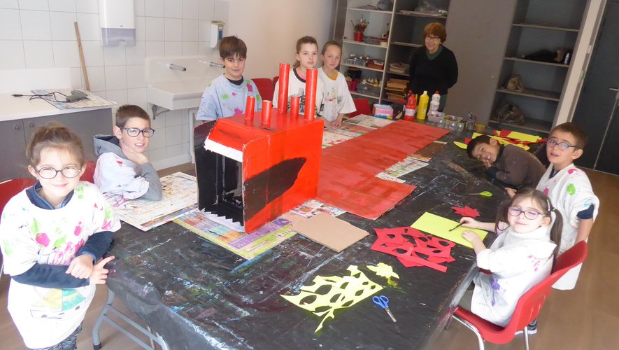 Les enfants aux côtés de Mireille Perrin en train de fabriquer le Dragon.