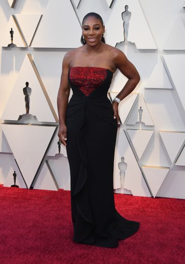 Toujours plus glamour, Serena Williams foule le tapis rouge dans un fourreau noir rehaussé de rouge brillant au niveau de la poitrine pour assister à la cérémonie des Oscars. Hollywood, le 24 février 2019.
