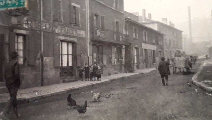 À gauche, l’hôtel de la Paix chez Fraux, avec des enfants et des poulesdans la rue au début du XXe siècle.