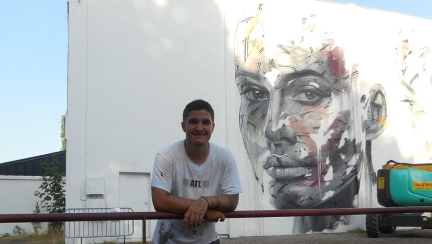 L’artiste Hopare qui a réalisé deux magnifiques visages sur le mur ouest du gymnase du lycée.