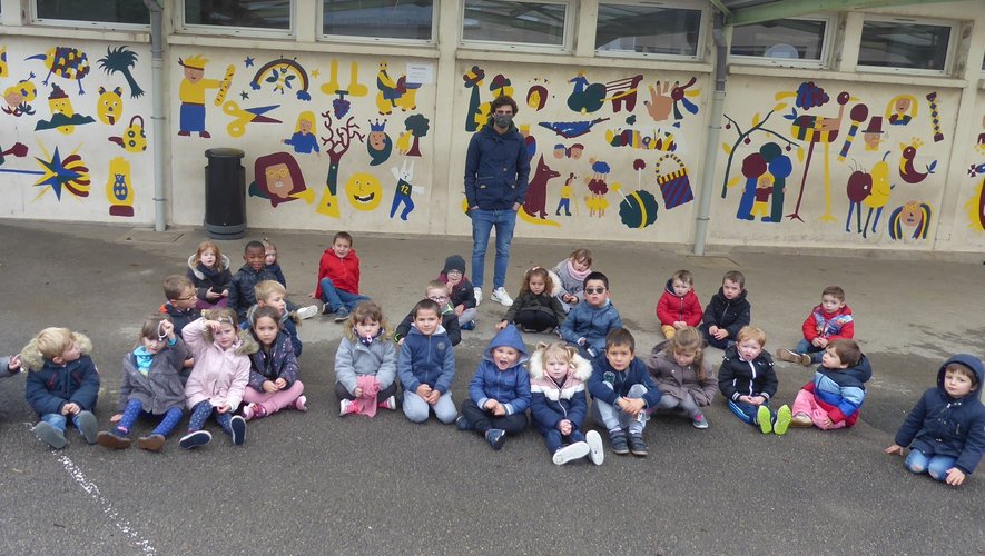 Les enfants de 3-5 ans aux côtés de Samuel dans la cour de l’école Jean-Boudou.