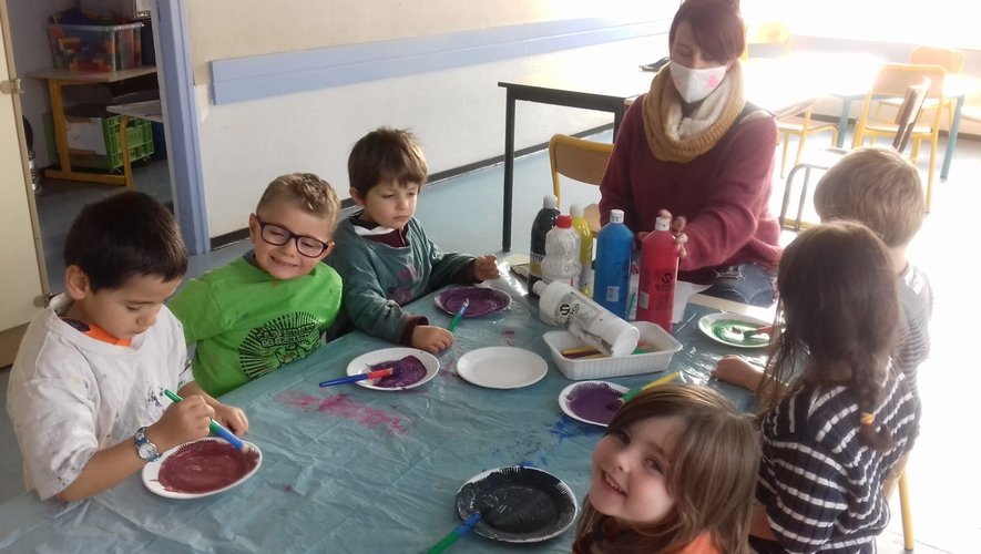 Quelques enfants de 3-5 ans autour de Mélanie tout heureux de mélanger des couleurs.