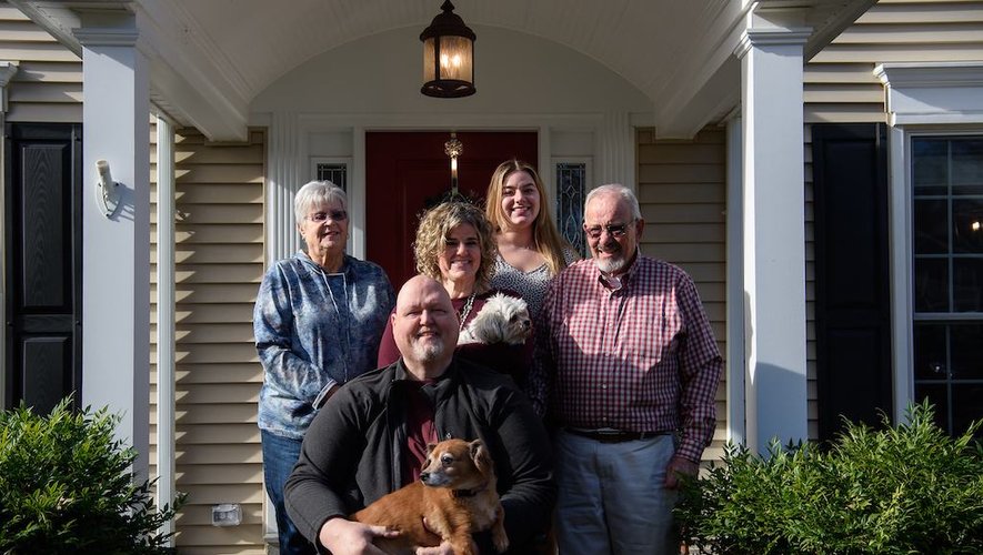 Eric Marcoux (C) pose avec sa femme Katie (2e rangée C), les parents de Katie, Judy Christensen (G) e Dano Christensen (R), et la fille de Katie, Eva Kolb devant leur maison à Potomac, Maryland, le 3 décembre 2020.