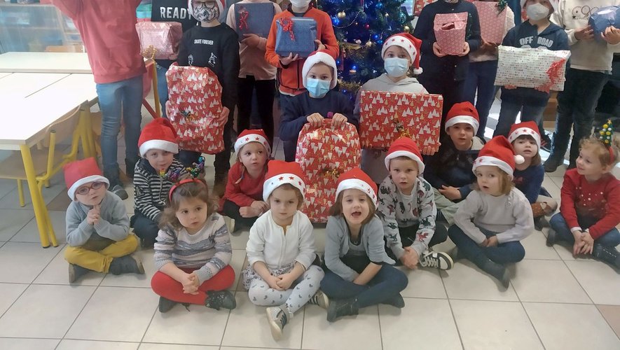 Des enfants heureux de découvrir les cadeaux de Noël.