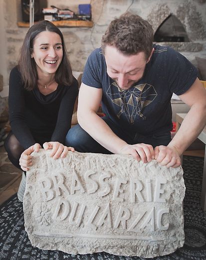 Rémi Vignollet et Camille Foulquié ont reçu un cadeau du grand-père de cette dernière, tailleur de pierre. La stèle indiquera l’entrée de la nouvelle brasserie.    