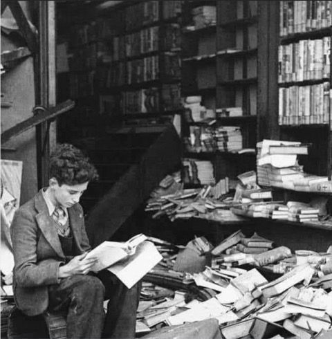 Londres, 8 octobre 1940 , un jeune garçon lit dans une librairie bombardée