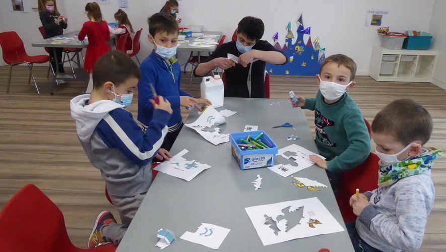 Les enfants encadrés par Maïlys, Loïc et Adrien, réalisant des paper toys.