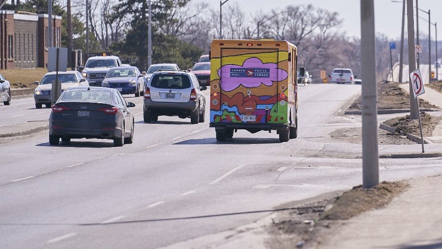 Une fourgonnette de Postes Canada peinte d'œuvres d'art colorées roule sur une route à London, en Ontario, le 12 mars 2021.