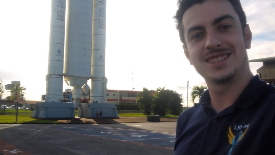Avec son sourire de circonstance, Sylvain Anglade pose devant la réplique du lanceur Ariane 5 installé à l’entrée du centre spatial guyannais. 	SA