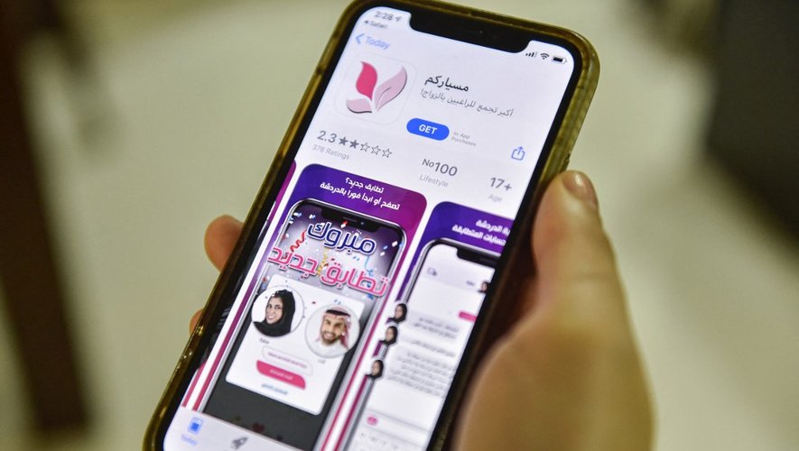 Une femme tient un appareil Apple iPhone montrant sur son App Store une application pour faciliter le mariage "Misyar", disponible en Arabie saoudite, dans la capitale Riyad.