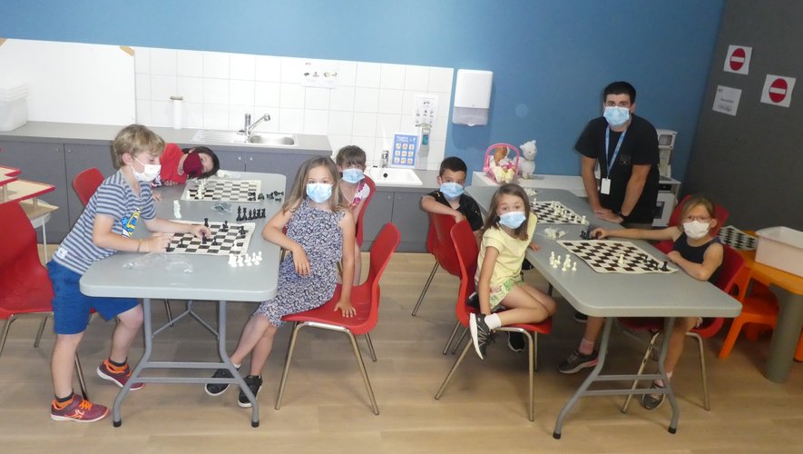 Un groupe d’enfants jouant aux échecs avec François, responsable de l’accueil de loisirs.