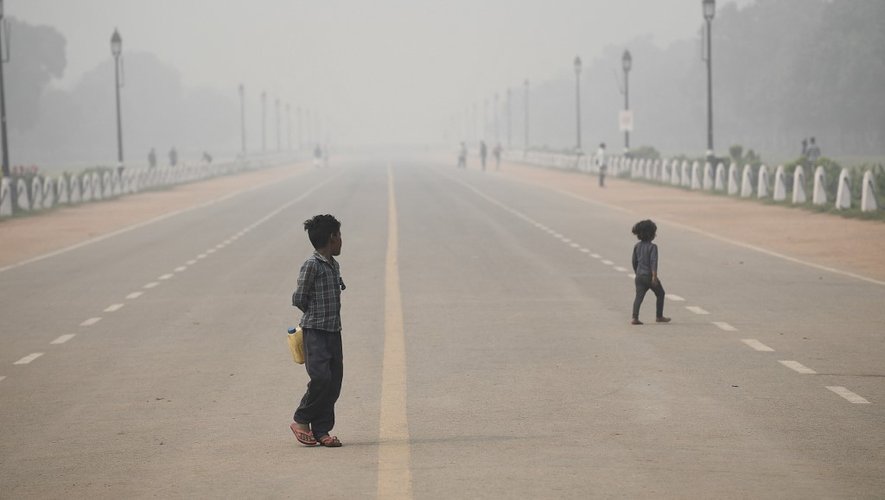 Des enfants marchent le long de Rajpath près de la Porte de l'Inde dans des conditions de smog intense à New Delhi, le 9 novembre 2020.