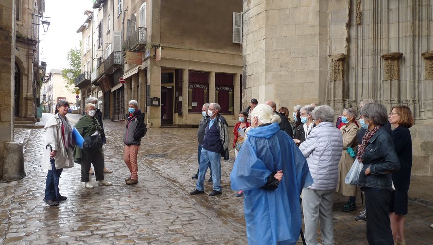 En chemin vers la maison Dufau, le groupe de visiteurs arrêté devant le porche de la collégiale de Villefranche-de-Rouergue.