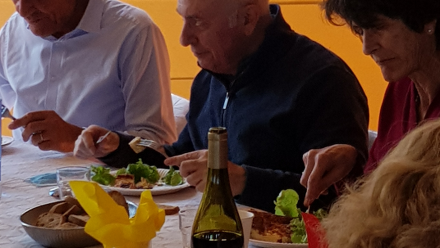 Le père Jean-Claude Lazuech (au milieu) partage le repas avec les bénévoles.