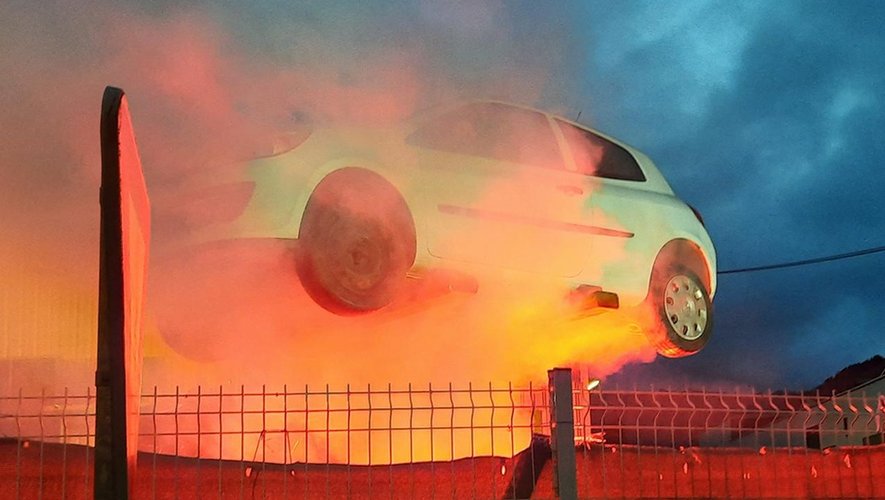 Le visuel montrant une voiture en feu symboliquement.