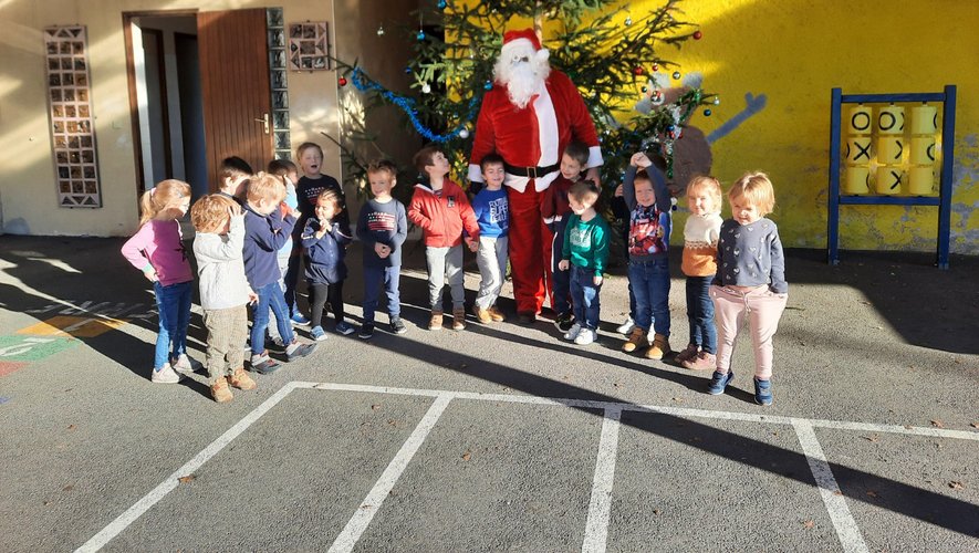 Les enfants de l’école primaire, heureux de recevoir le père Noël et des cadeaux.