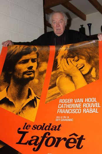 Guy Cavagnac devant l'affiche de son film.