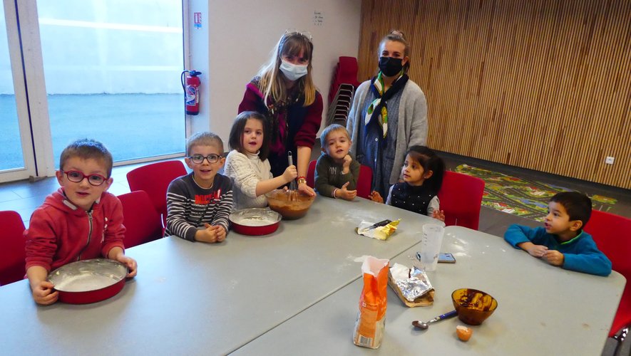 Un groupe d’enfants encadrés par Coralie et Laura, fiers de concocter  le gâteau au chocolat.