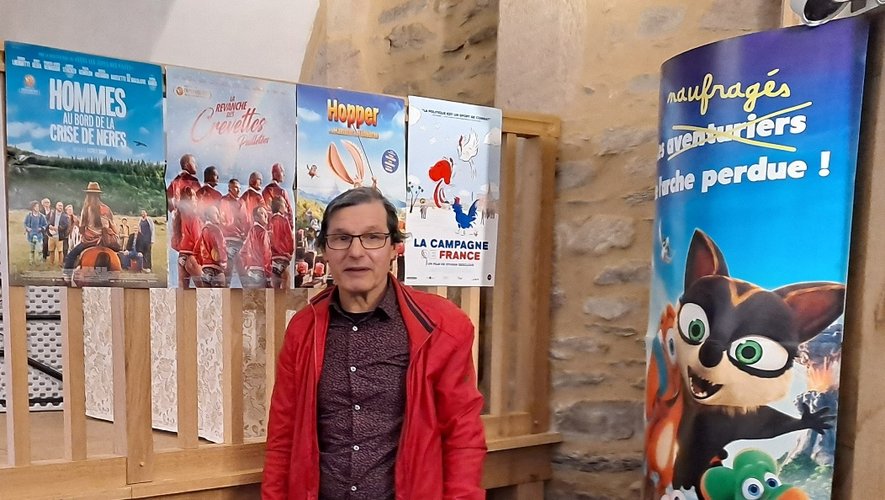 Hervé devant les affiches des films récemment diffusés à Salles-Curan.