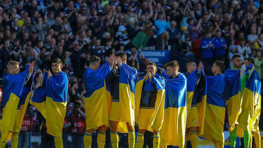 Les joueurs ukrainiens enroulés dans leur drapeau lors des hymnes, avant la demi-finale des barrages pour le Mondial contre l'Ecosse, mercredi 1er juin à Glasgow, où ils se sont imposés (3-1). 