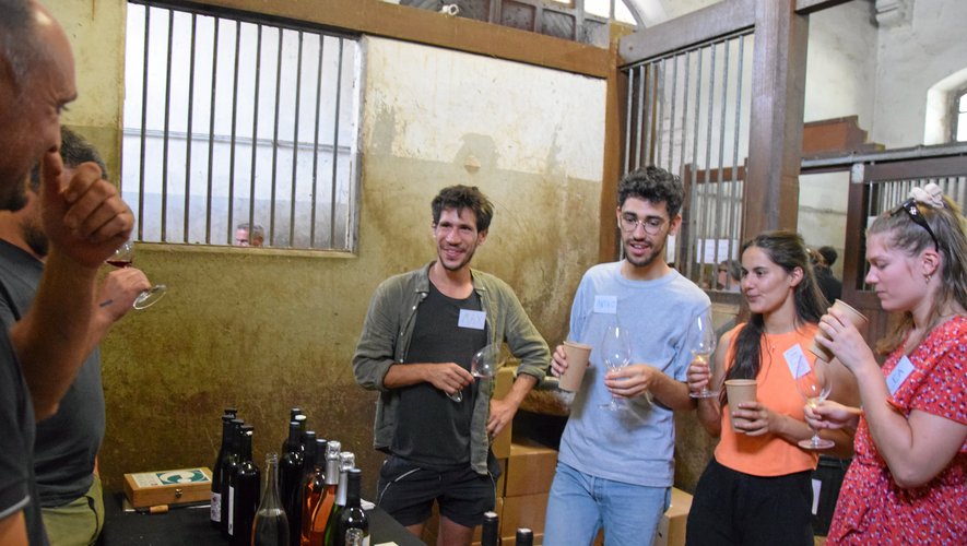 Des étudiants gouttent au breuvage au premier salon du vin naturel aux haras de Rodez. 